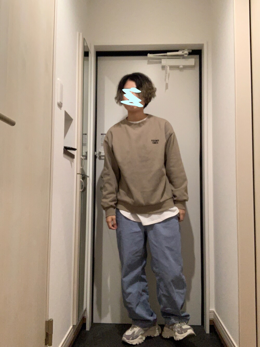 ブラック系のトレンチコート、グレー系のスウェット、ブルー系のパンツを着用したレディースの冬コーディネートの2枚目の写真