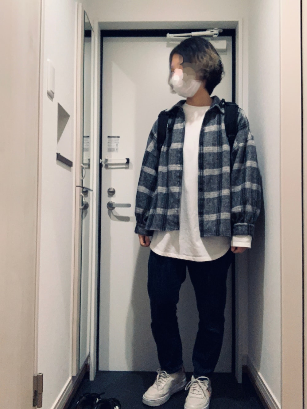 ブルー系のデニムパンツ、ホワイト系のスニーカー、ブラック系のバックパック/リュックを着用したレディースの春コーディネートの2枚目の写真