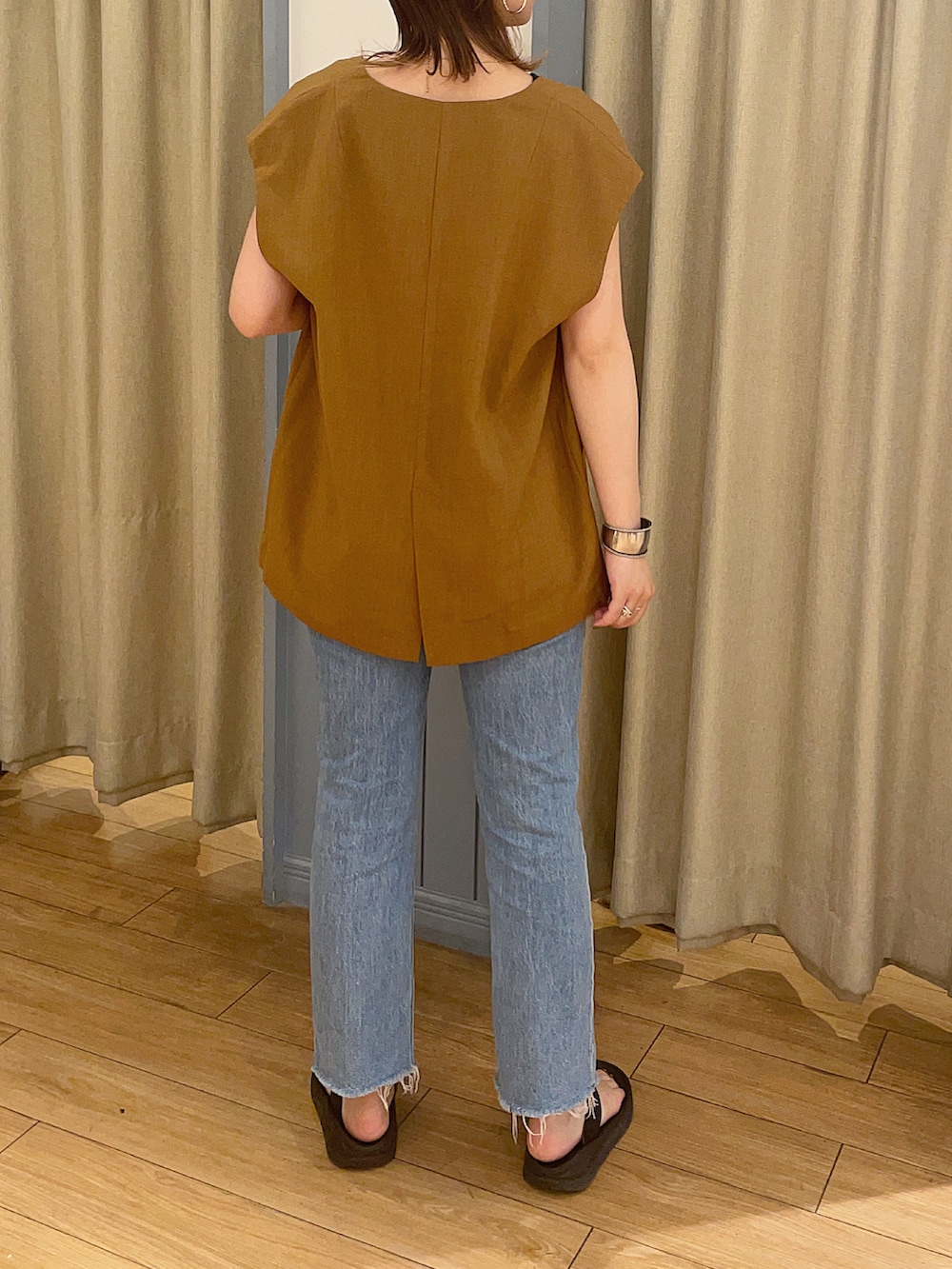 ブルー系のデニムパンツ、ブラック系のサンダル、ブラウン系のジャケット/アウターを着用したレディースの夏コーディネートの3枚目の写真