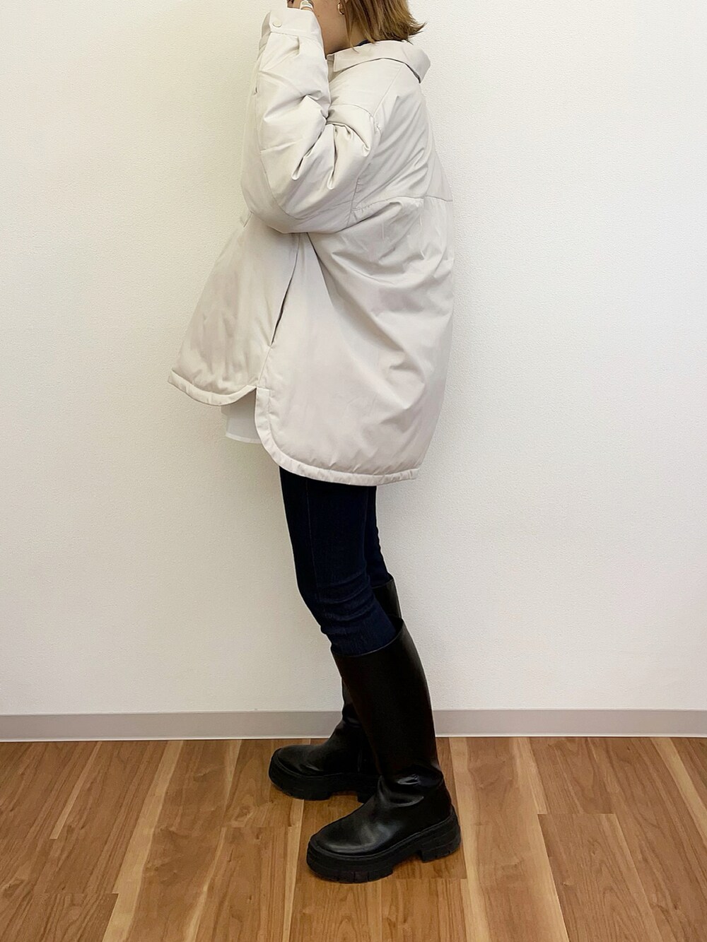 ブラック系のブーツ、ブラック系のデニムパンツ、ブルー系のニット/セーターを着用したレディースの冬コーディネートの3枚目の写真