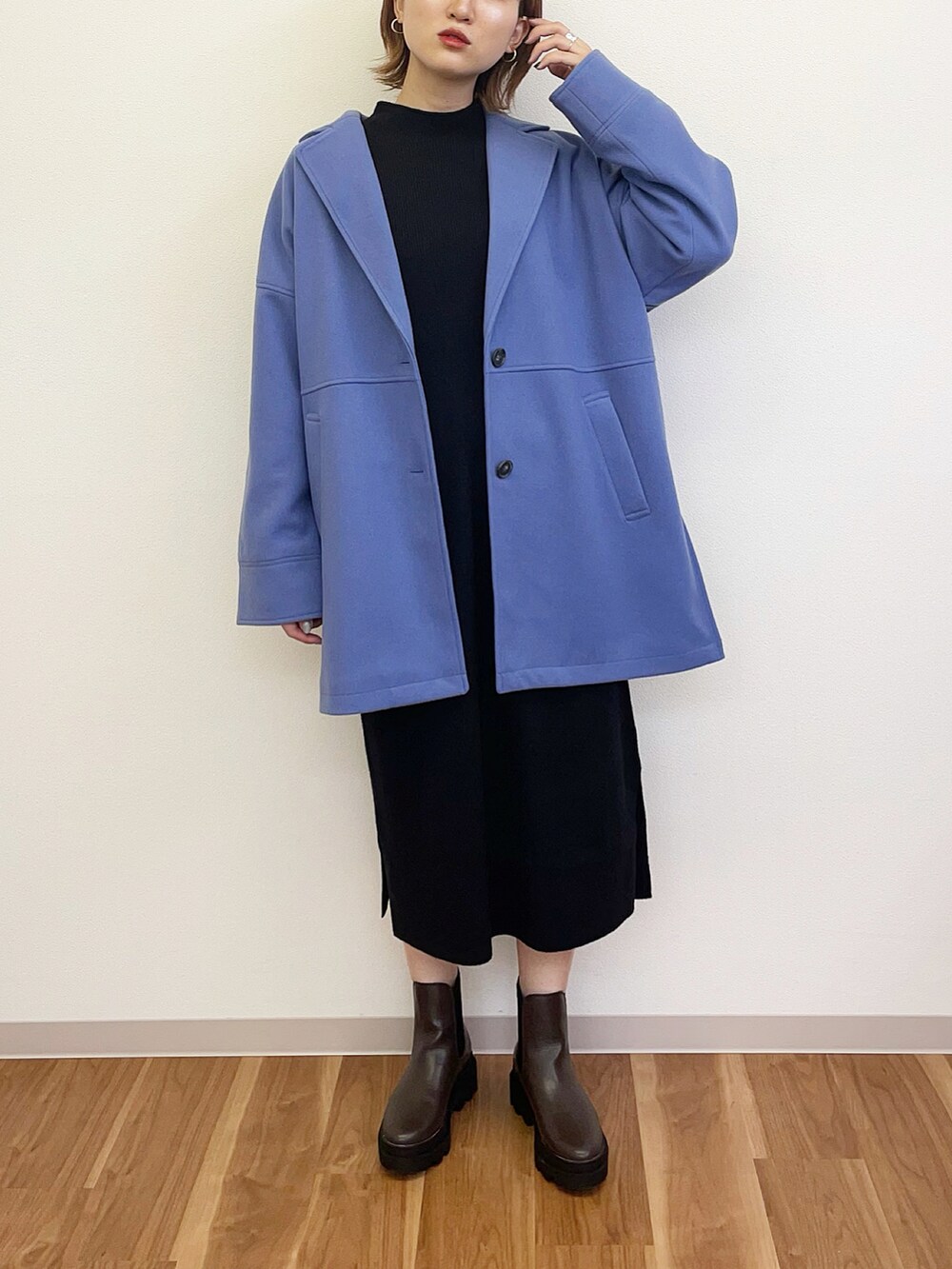 ブラック系のワンピース、ブルー系のテーラードジャケット、ブラウン系のブーツを着用したレディースの秋コーディネートの2枚目の写真