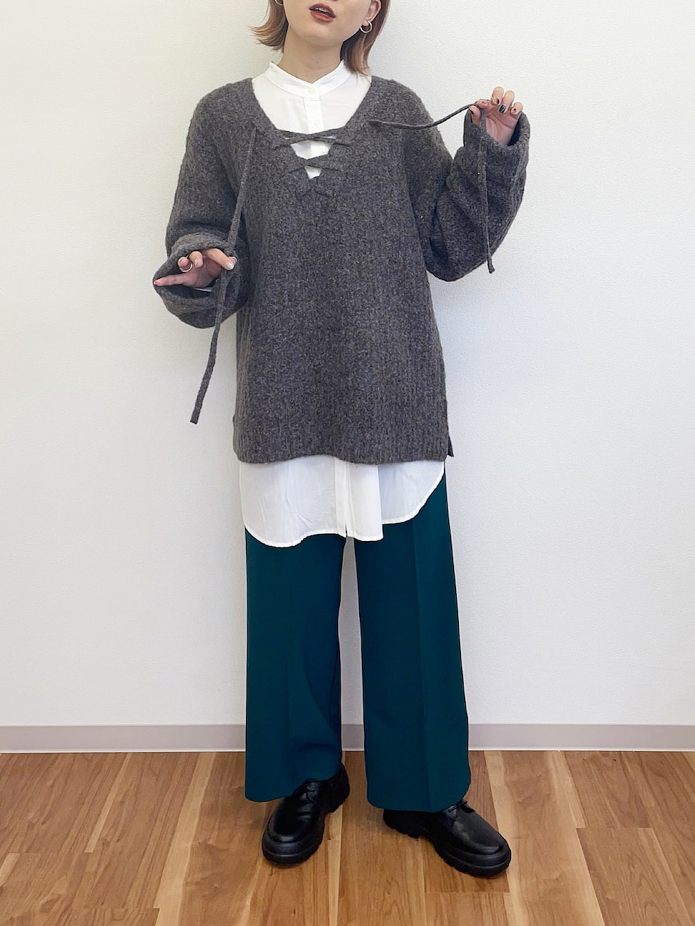 グリーン系のその他パンツ、ブラック系のその他シューズ、グレー系のニット/セーターを着用したレディースの冬コーディネートの2枚目の写真