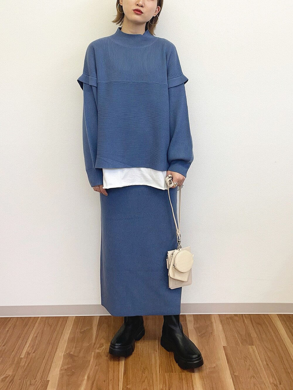 ブルー系のワンピース、ブラック系のブーツ、ホワイト系のショルダーバッグを着用したレディースの冬コーディネートの2枚目の写真