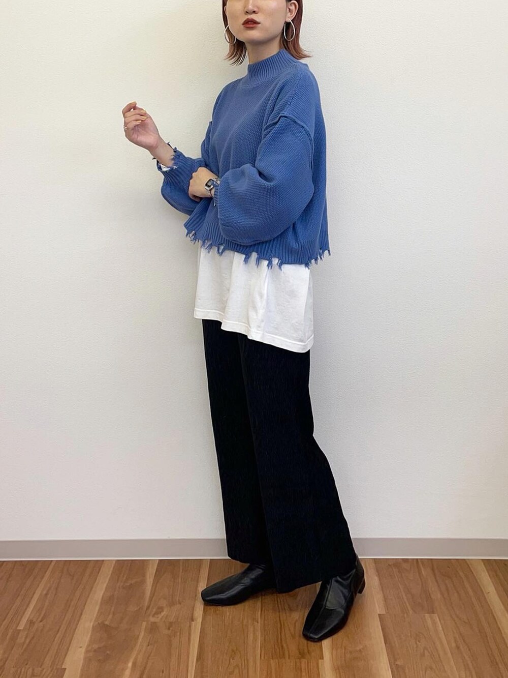 ブルー系のニット/セーター、ブラック系のその他パンツ、ブラック系のブーツを着用したレディースの冬コーディネートの3枚目の写真