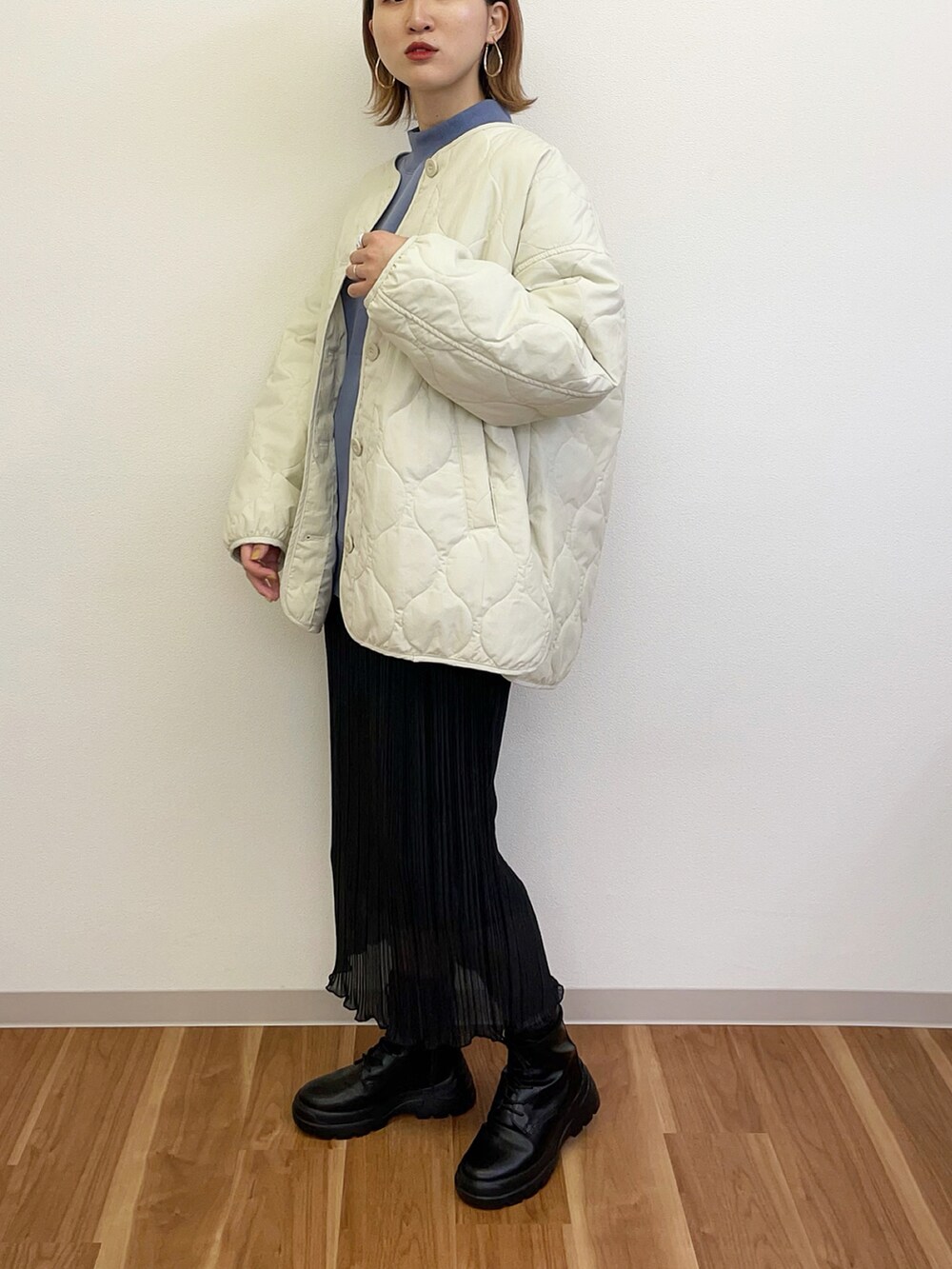 ブラック系のスカート、ブルー系のスウェット、ホワイト系のブルゾンを着用したレディースの冬コーディネートの3枚目の写真