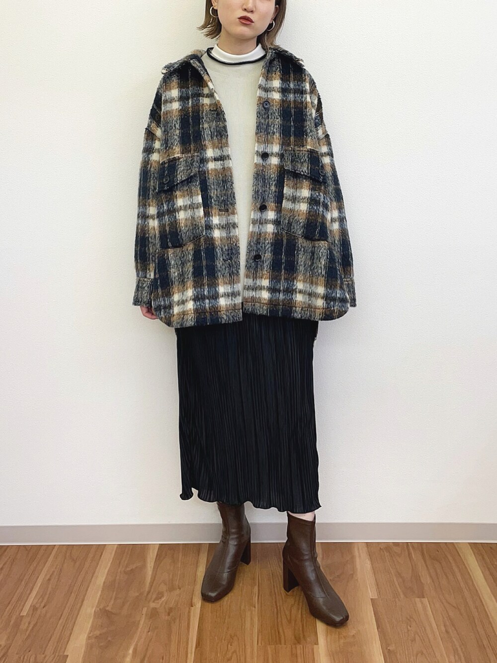 ブラック系のスカート、ブルー系のテーラードジャケット、ホワイト系のニット/セーターを着用したレディースの冬コーディネートの2枚目の写真