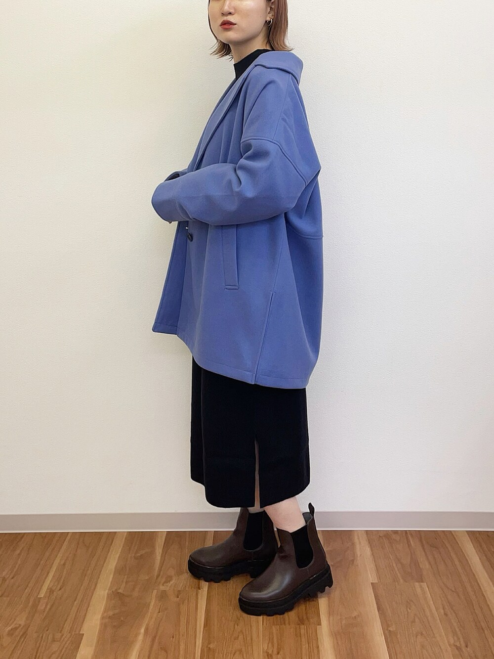 ブラック系のワンピース、ブルー系のテーラードジャケット、ブラウン系のブーツを着用したレディースの秋コーディネートの3枚目の写真