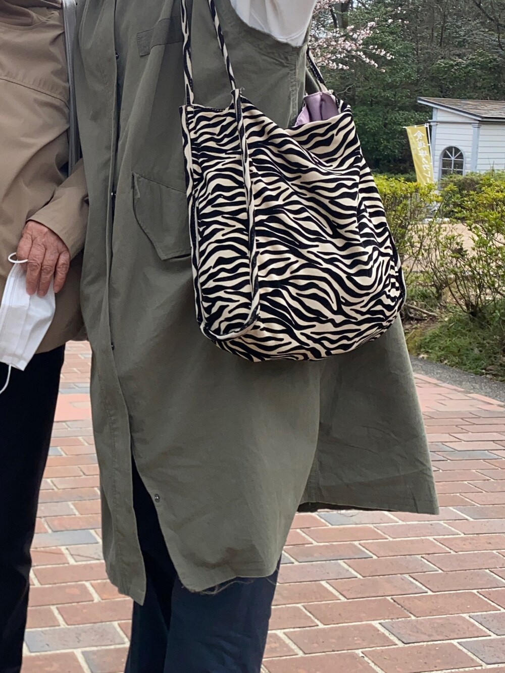 ホワイト系のスウェット、グリーン系のその他アウター、ブルー系のパンツを着用したレディースの春コーディネートの2枚目の写真