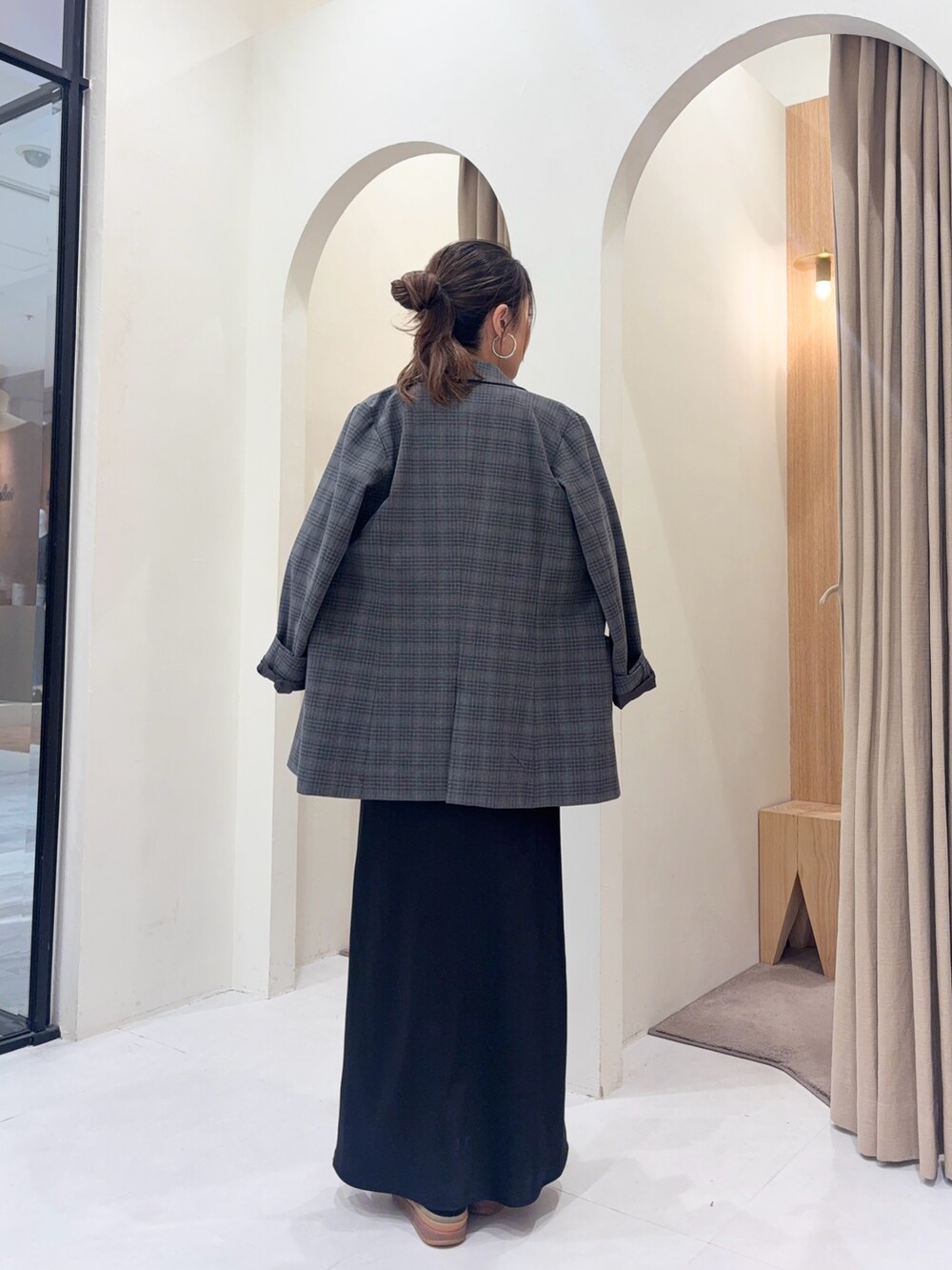 グレー系のテーラードジャケット、ブラック系のスカート、ブラック系のショルダーバッグを着用したレディースの秋コーディネートの4枚目の写真