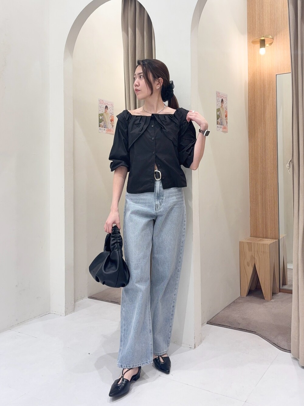 ブラック系のシャツ/ブラウス、ブラック系のショルダーバッグ、ブルー系のデニムパンツを着用したレディースの春コーディネートの3枚目の写真