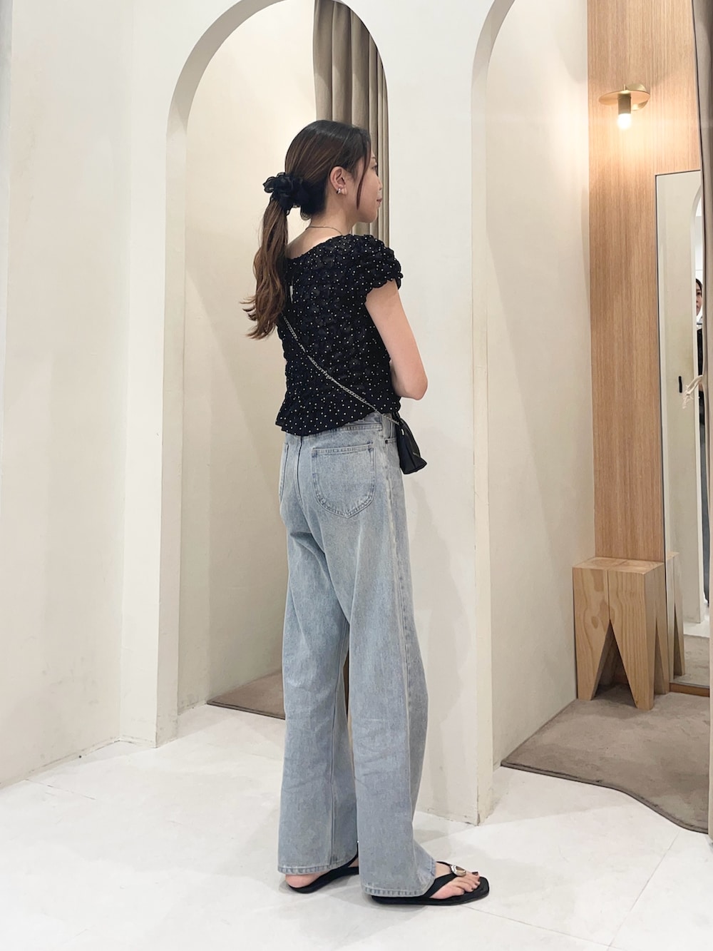 ブラック系のシャツ/ブラウス、ブラック系のショルダーバッグ、ブルー系のデニムパンツを着用したレディースの夏コーディネートの4枚目の写真