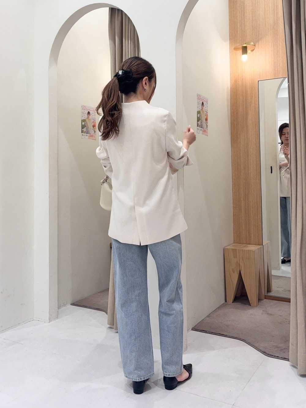 ホワイト系のショルダーバッグ、ホワイト系のその他アウター、ブルー系のデニムパンツを着用したレディースの春コーディネートの3枚目の写真
