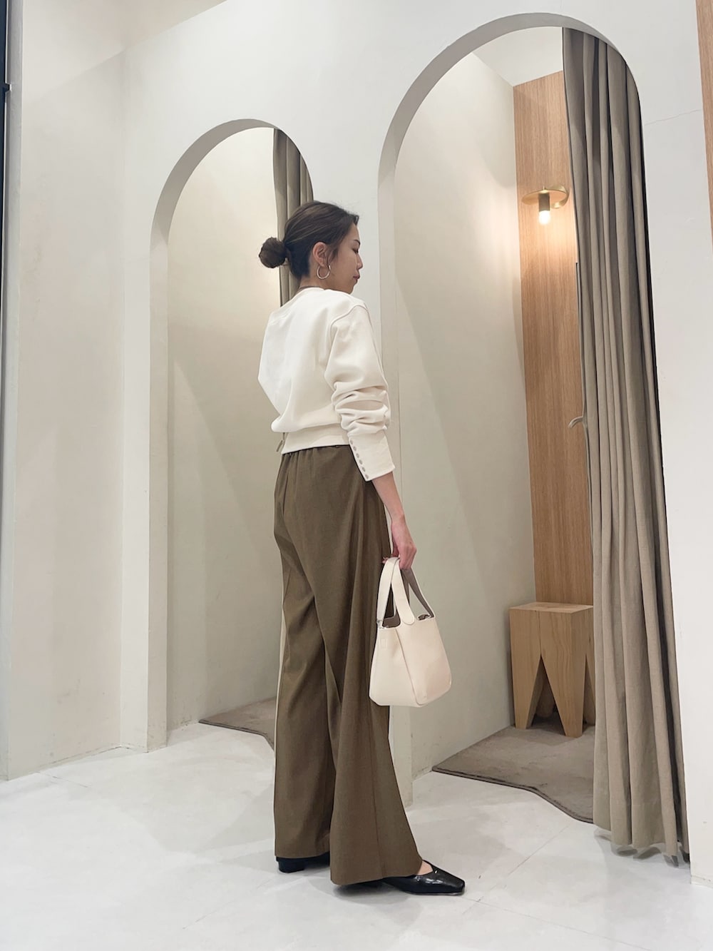 ホワイト系のTシャツ/カットソー、ホワイト系のショルダーバッグ、ブラウン系のその他パンツを着用したレディースの冬コーディネートの2枚目の写真