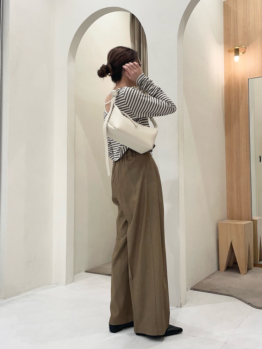 ホワイト系のTシャツ/カットソー、ホワイト系のショルダーバッグ、ブラウン系のその他パンツを着用したレディースの冬コーディネートの3枚目の写真