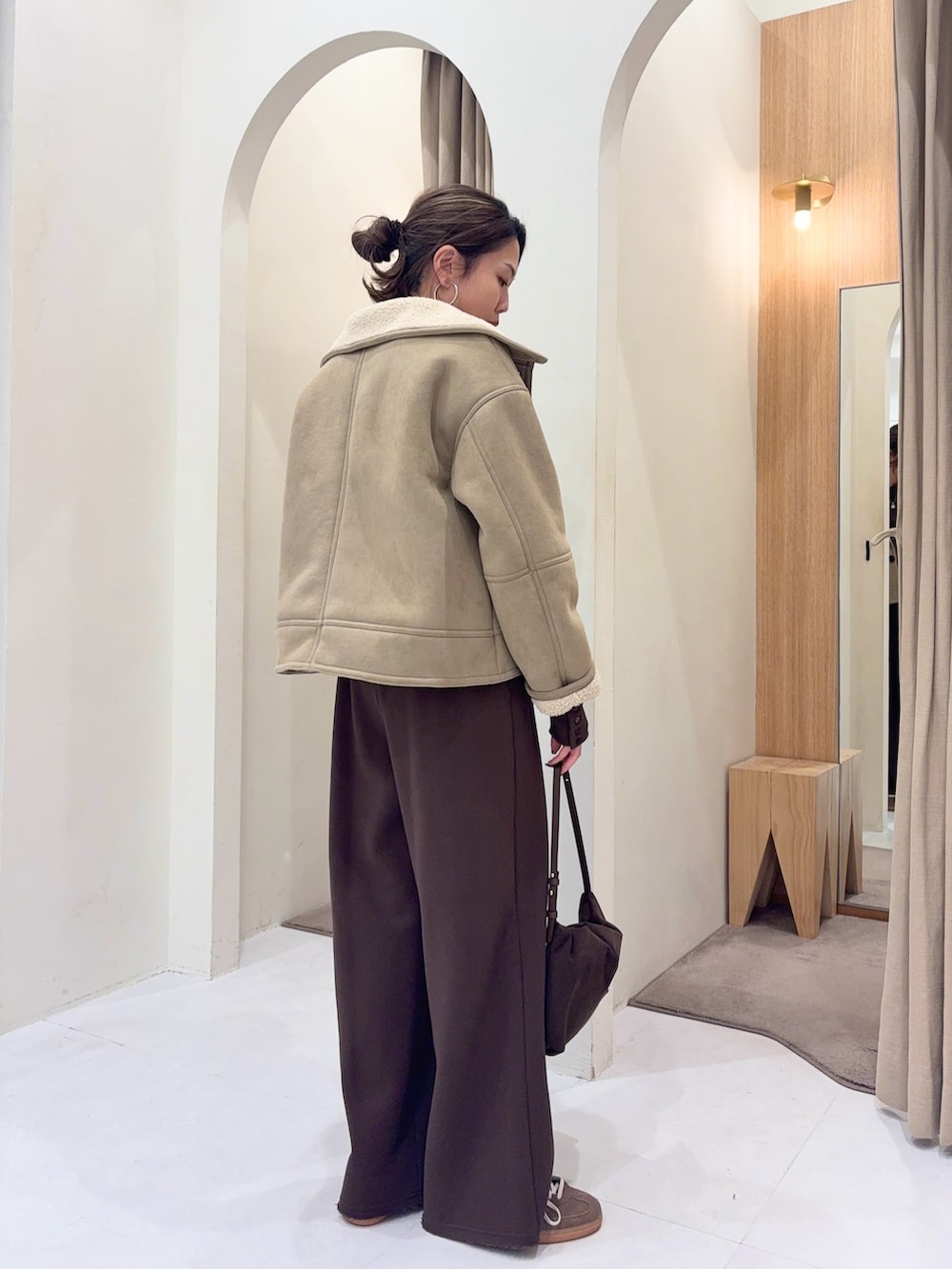 ブラウン系のTシャツ/カットソー、ベージュ系のその他アウター、ブラウン系のショルダーバッグを着用したレディースの冬コーディネートの3枚目の写真