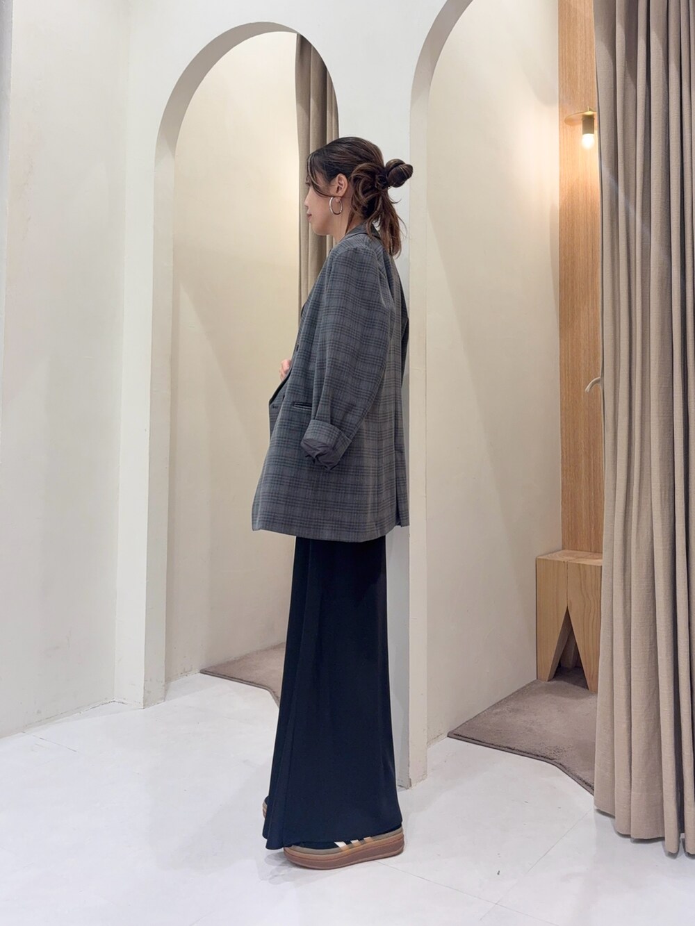 グレー系のテーラードジャケット、ブラック系のスカート、ブラック系のショルダーバッグを着用したレディースの秋コーディネートの2枚目の写真