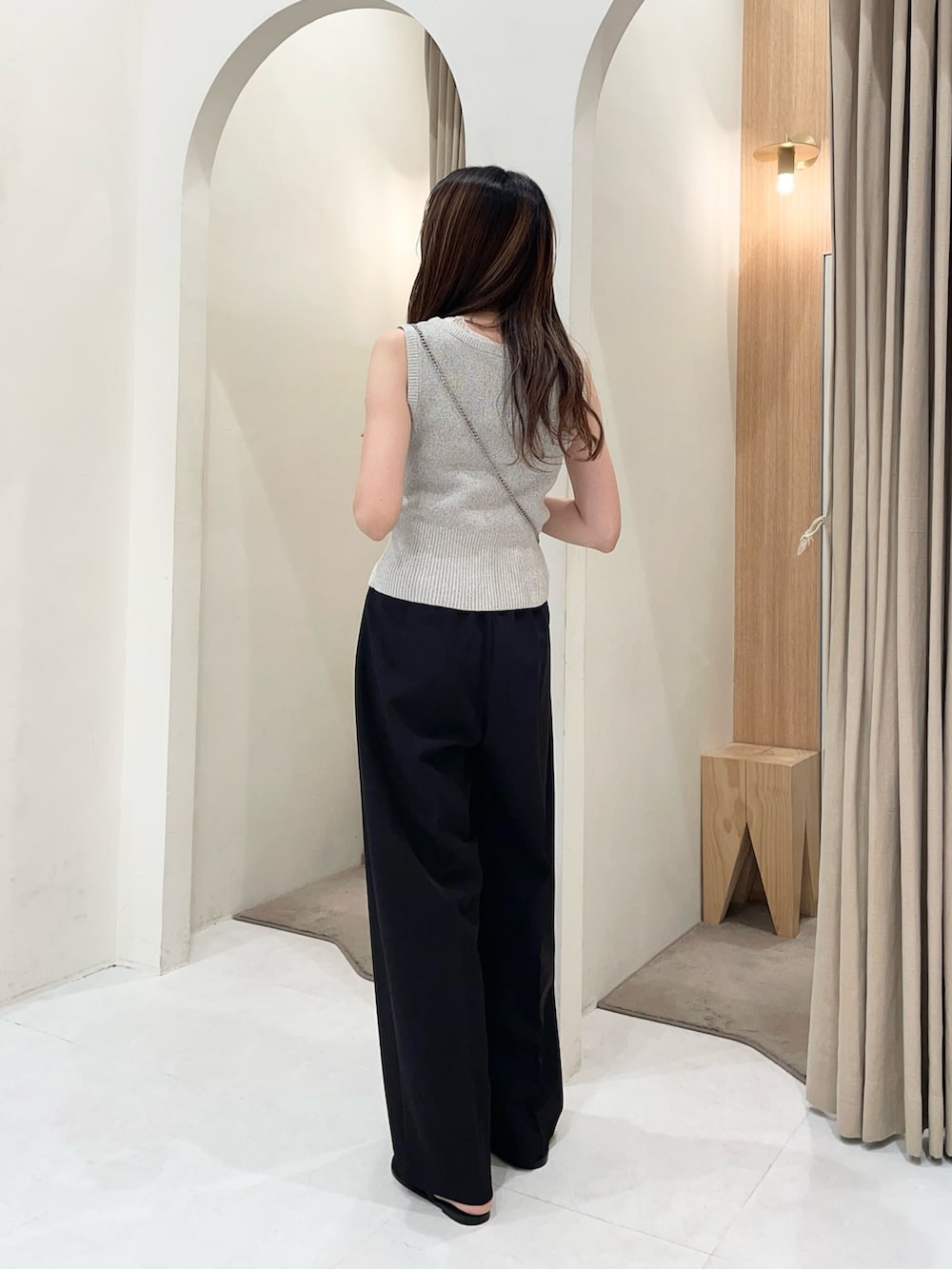 グレー系のニット/セーター、ブラック系のショルダーバッグ、ブラック系のその他パンツを着用したレディースの夏コーディネートの2枚目の写真