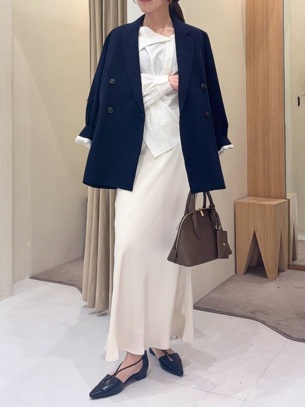 ブルー系のテーラードジャケット、ホワイト系のシャツ/ブラウス、ホワイト系のスカートを着用したレディースの冬コーディネートの4枚目の写真