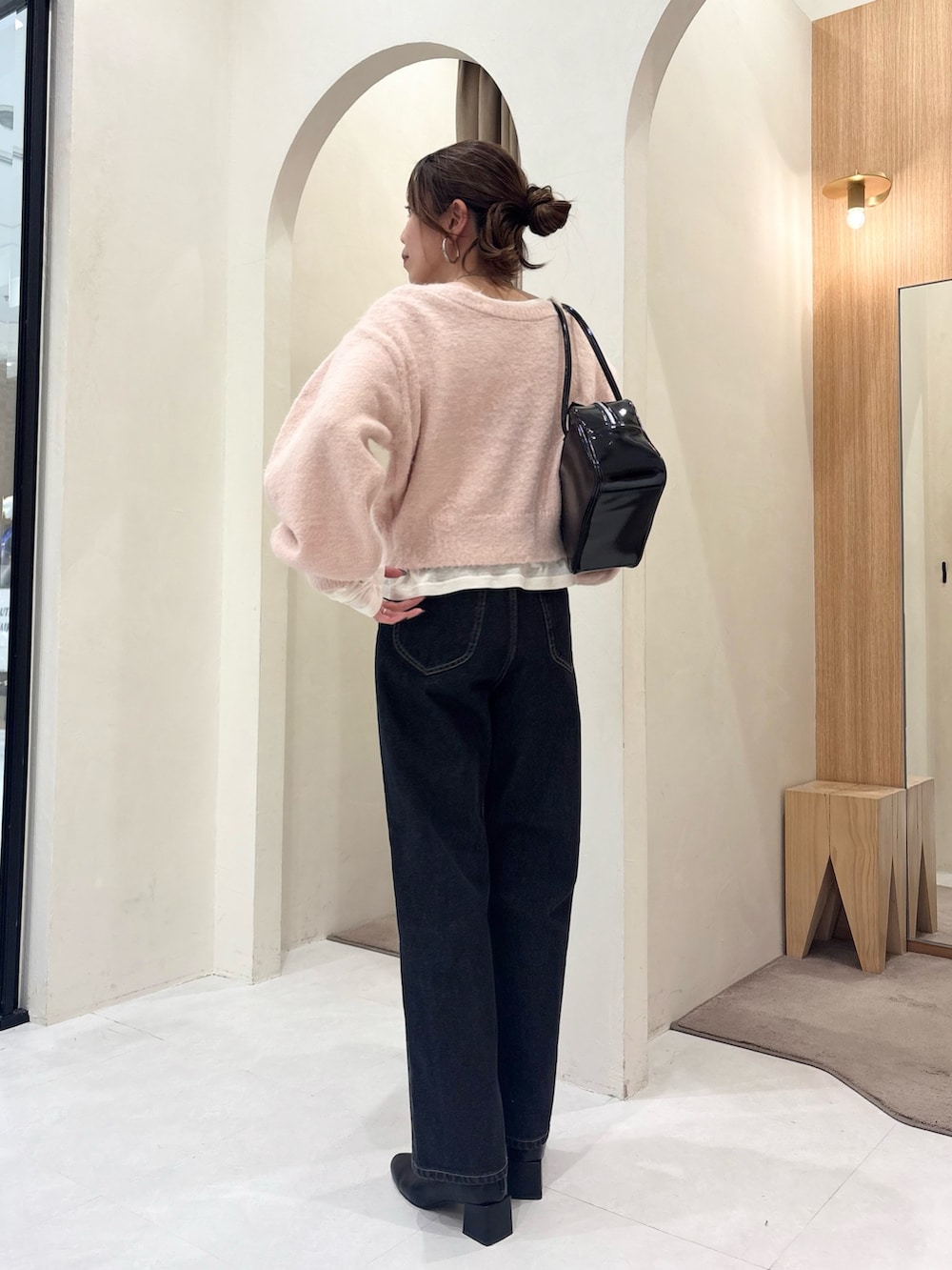 ピンク系のカーディガン/ボレロ、ブラック系のショルダーバッグ、ホワイト系のTシャツ/カットソーを着用したレディースの冬コーディネートの3枚目の写真