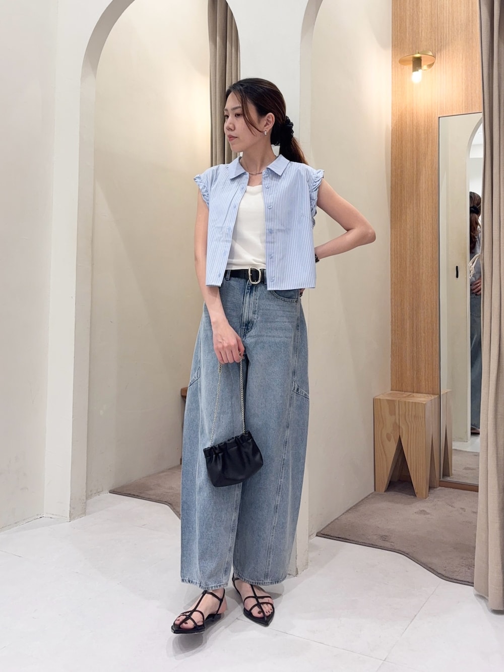 ブルー系のシャツ/ブラウス、ブルー系のデニムパンツ、ブラック系のショルダーバッグを着用したレディースの夏コーディネートの3枚目の写真