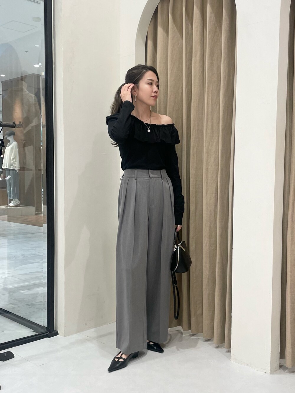 ブラック系のTシャツ/カットソー、グレー系のその他パンツ、ブラック系のパンプスを着用したレディースの春コーディネートの3枚目の写真