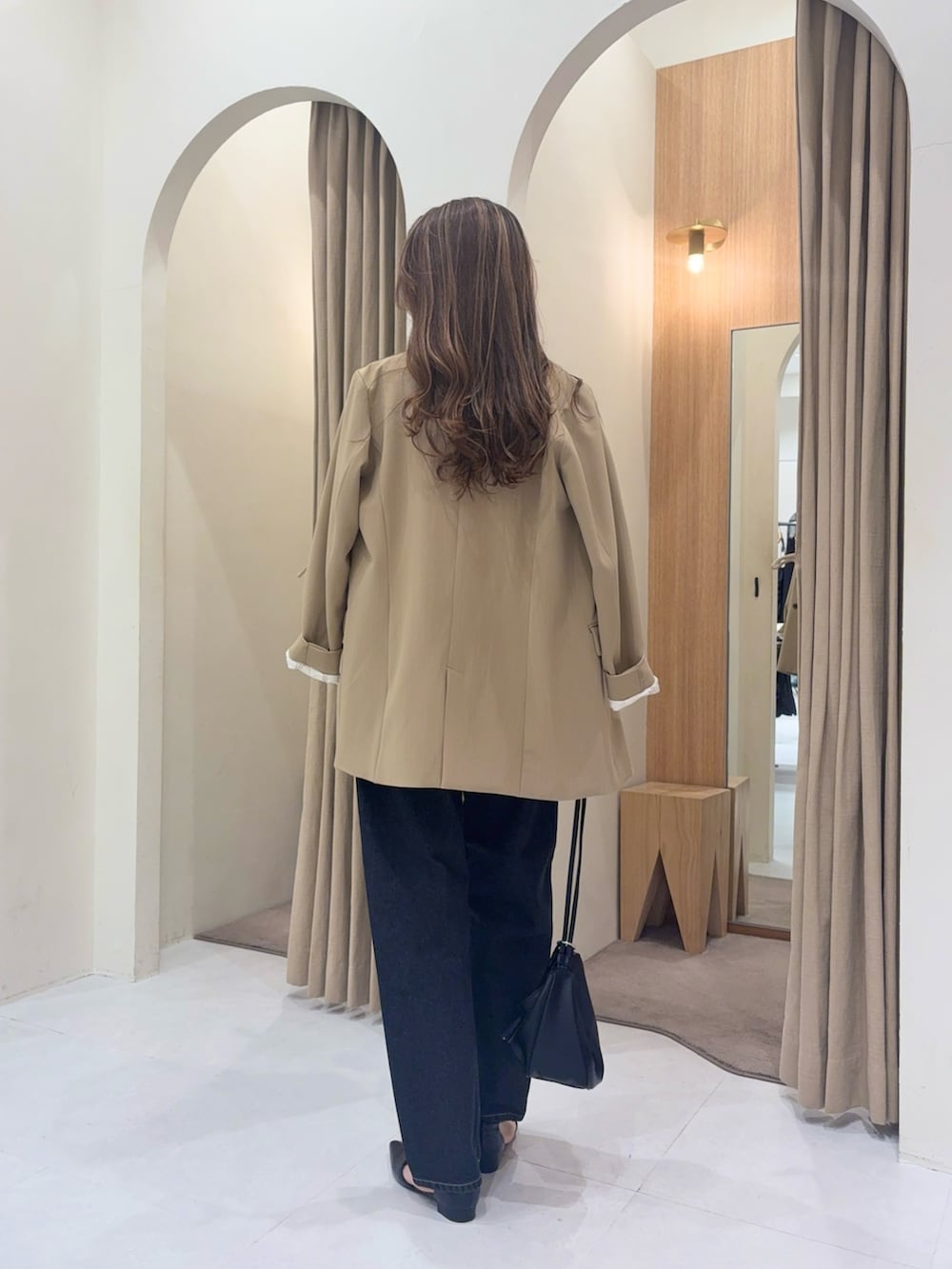 ベージュ系のテーラードジャケット、ホワイト系のTシャツ/カットソー、ブラック系のデニムパンツを着用したレディースの春コーディネートの3枚目の写真