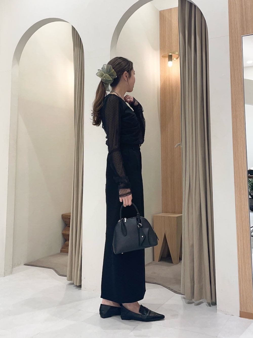 ブラック系のシャツ/ブラウス、ブラック系のスカート、ブラック系のショルダーバッグを着用したレディースの冬コーディネートの3枚目の写真