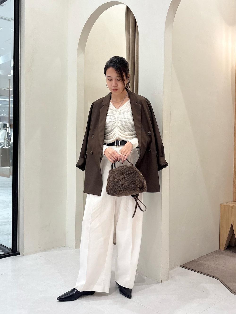ホワイト系のニット/セーター、ブラウン系のテーラードジャケット、ブラウン系のボストンバッグを着用したレディースの秋コーディネートの3枚目の写真