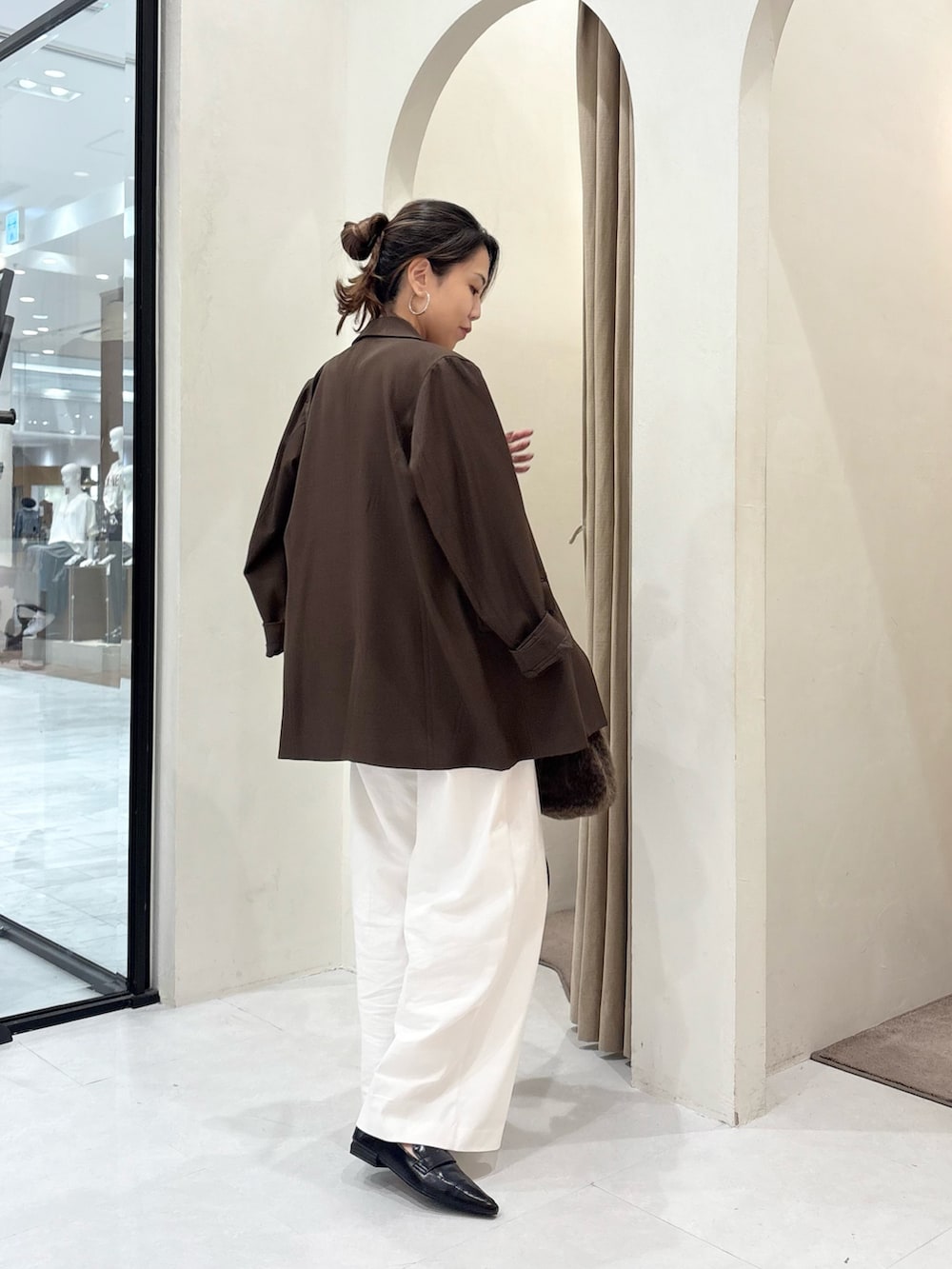 ホワイト系のニット/セーター、ブラウン系のテーラードジャケット、ブラウン系のボストンバッグを着用したレディースの秋コーディネートの2枚目の写真