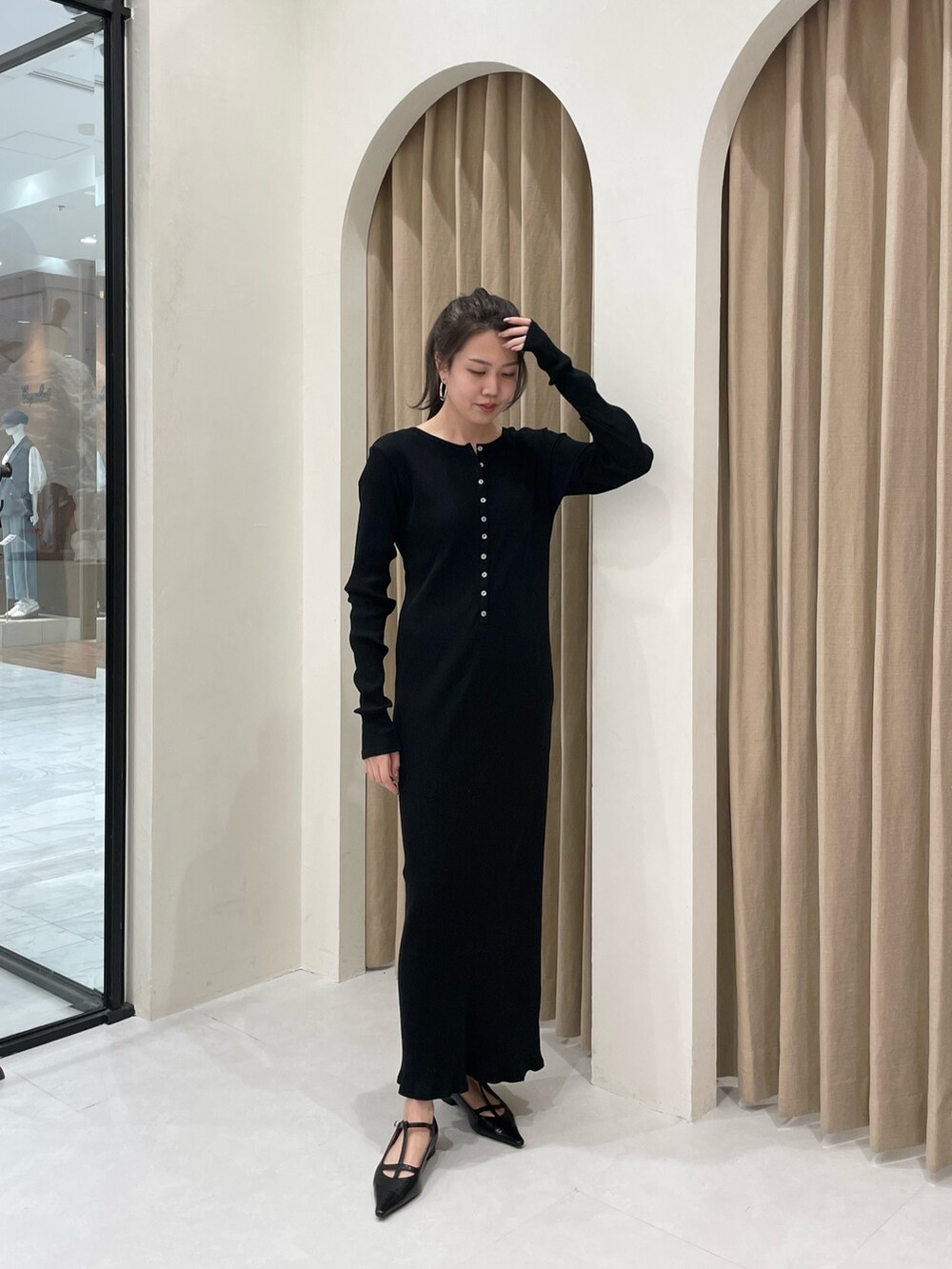 ブラック系のワンピース、ブラック系のパンプス、グレー系のシャツ/ブラウスを着用したレディースの春コーディネートの4枚目の写真