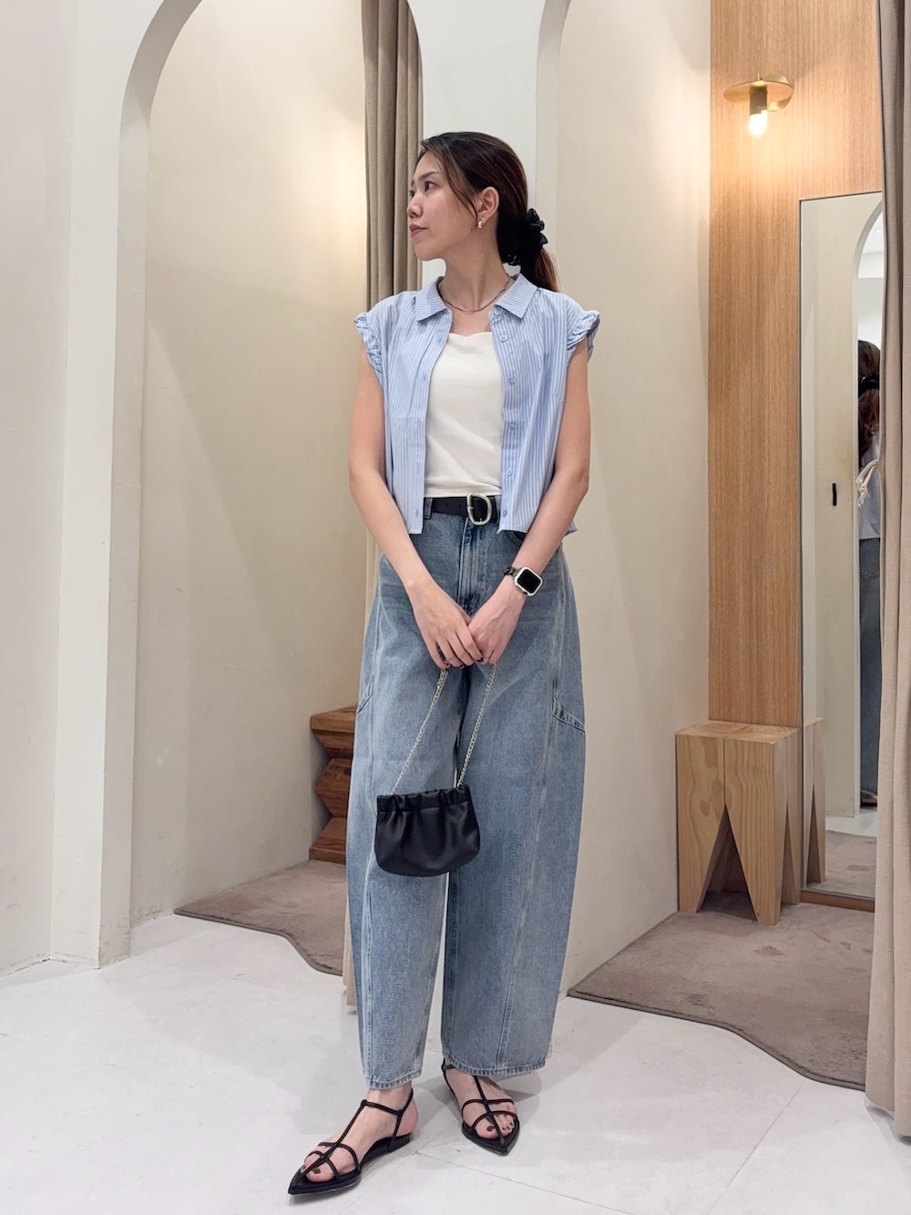 ブルー系のシャツ/ブラウス、ブルー系のデニムパンツ、ブラック系のショルダーバッグを着用したレディースの夏コーディネートの2枚目の写真