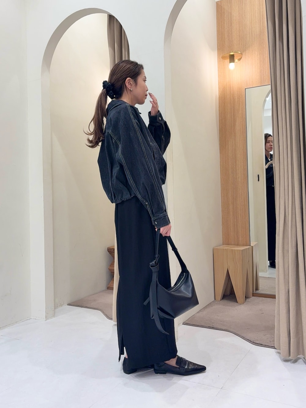 ブラック系のブルゾン、ホワイト系のカーディガン/ボレロ、ブラック系のスカートを着用したレディースの春コーディネートの3枚目の写真