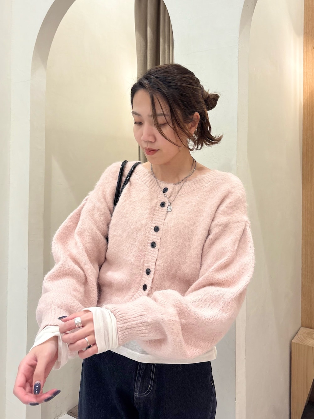 ピンク系のカーディガン/ボレロ、ブラック系のショルダーバッグ、ホワイト系のTシャツ/カットソーを着用したレディースの冬コーディネートの5枚目の写真