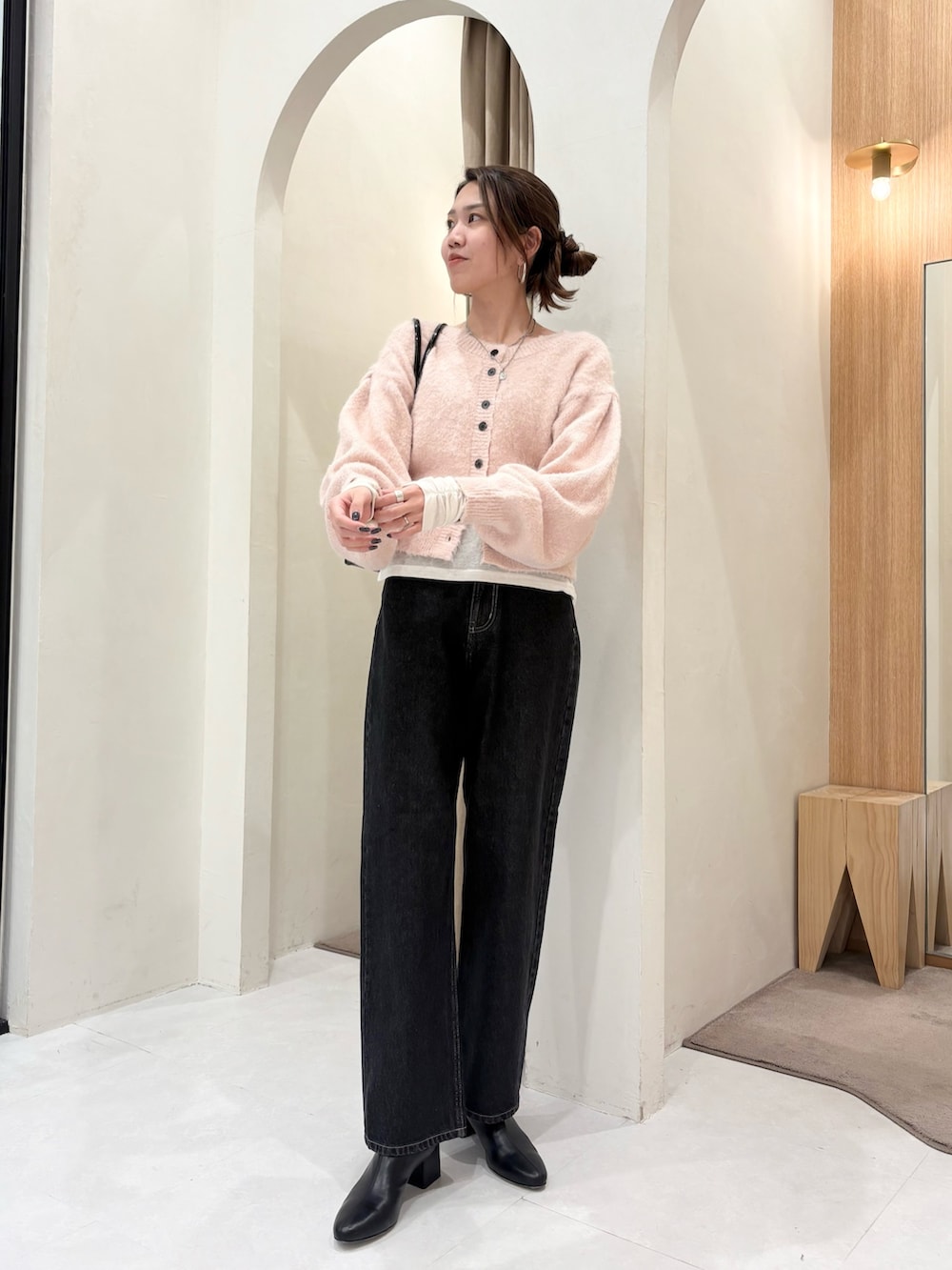 ピンク系のカーディガン/ボレロ、ブラック系のショルダーバッグ、ホワイト系のTシャツ/カットソーを着用したレディースの冬コーディネートの4枚目の写真