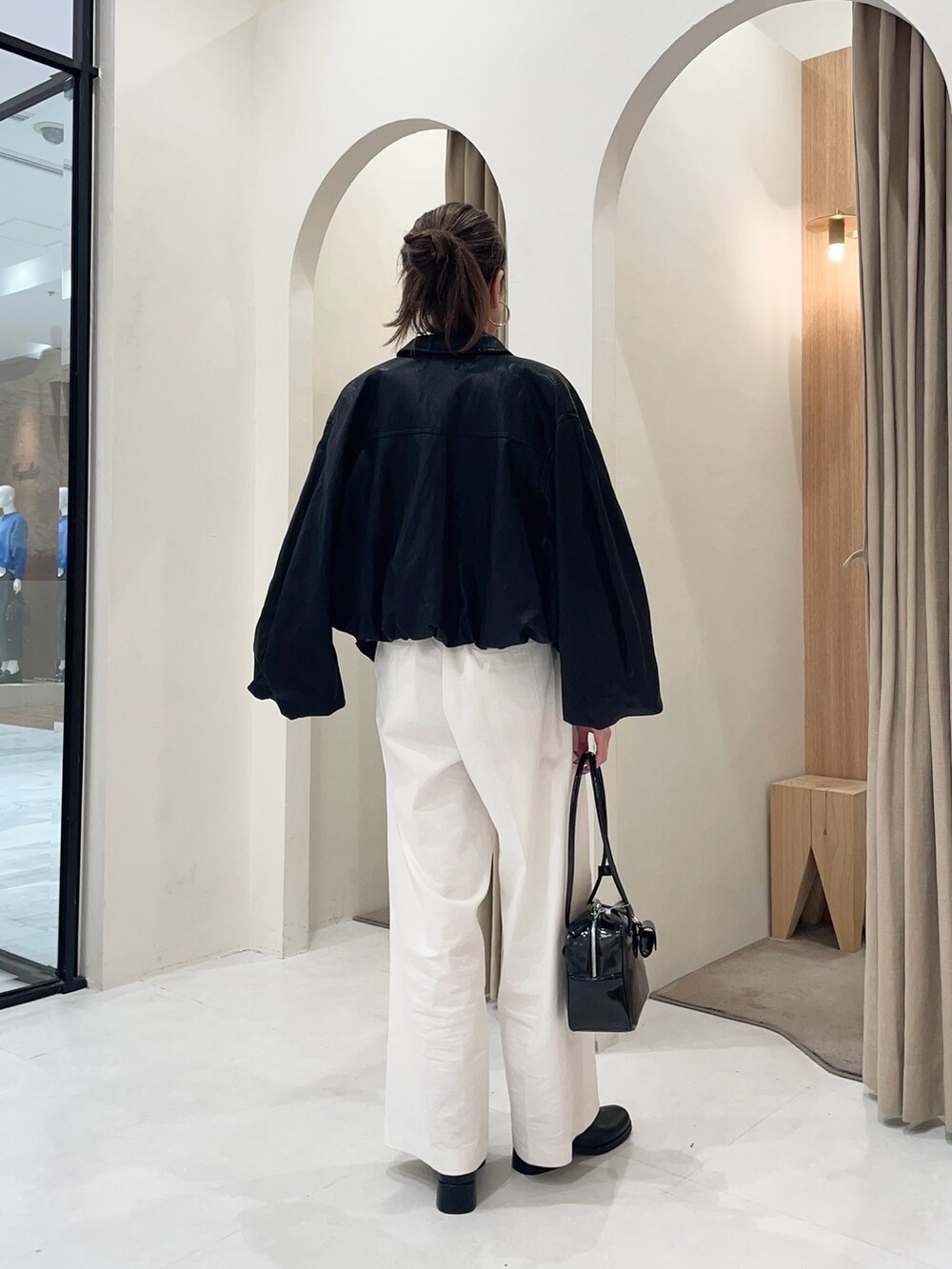 ブラック系のブルゾン、ブラック系のカーディガン/ボレロ、ホワイト系のその他パンツを着用したレディースの秋コーディネートの5枚目の写真