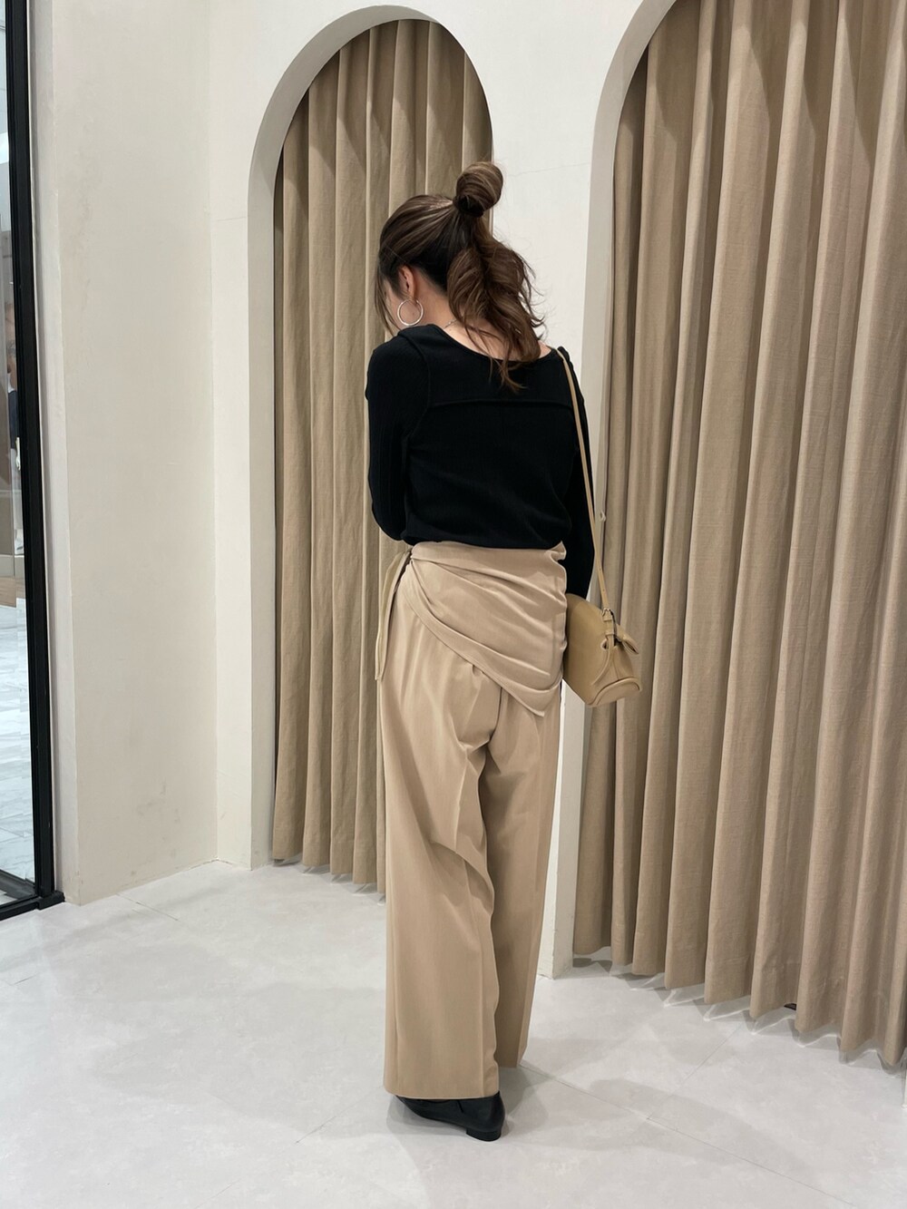 ブラック系のTシャツ/カットソー、ベージュ系のショルダーバッグ、ベージュ系のその他パンツを着用したレディースの春コーディネートの2枚目の写真