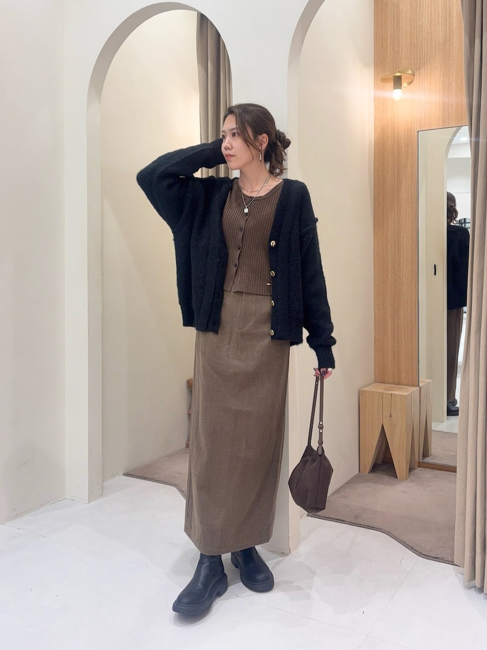 ブラウン系のカーディガン/ボレロ、ブラウン系のスカート、ブラック系のカーディガン/ボレロを着用したレディースの秋コーディネートの3枚目の写真