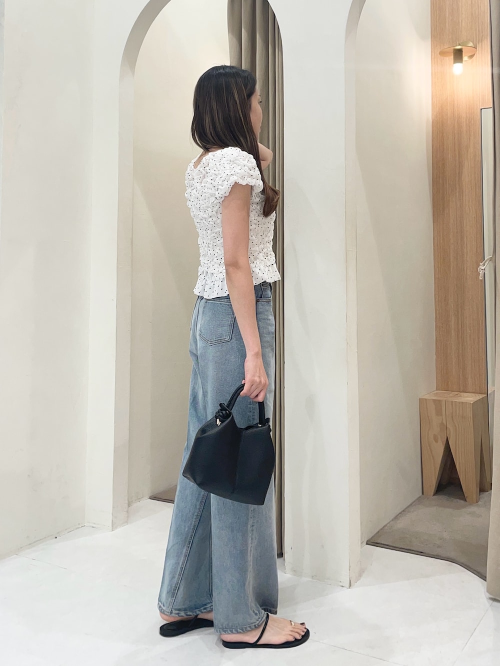 ホワイト系のシャツ/ブラウス、ブラック系のショルダーバッグ、ブルー系のデニムパンツを着用したレディースの夏コーディネートの3枚目の写真