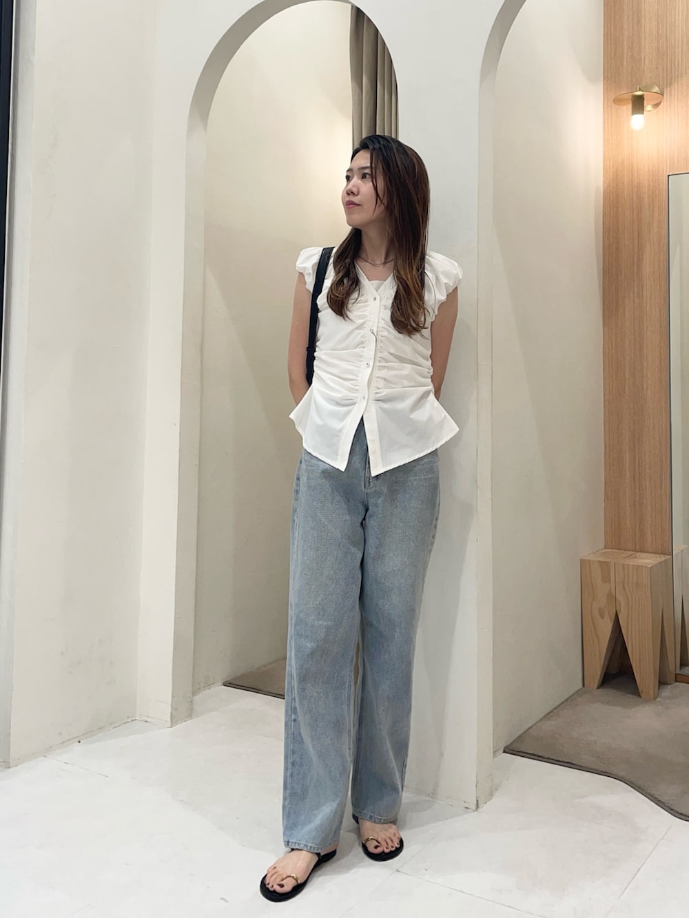 ホワイト系のシャツ/ブラウス、ブルー系のデニムパンツ、ブラック系のショルダーバッグを着用したレディースの夏コーディネートの4枚目の写真