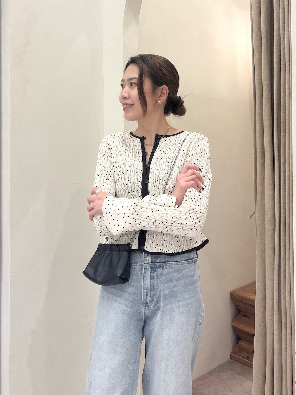 ホワイト系のシャツ/ブラウス、ブラック系のショルダーバッグ、ブルー系のデニムパンツを着用したレディースの冬コーディネートの4枚目の写真