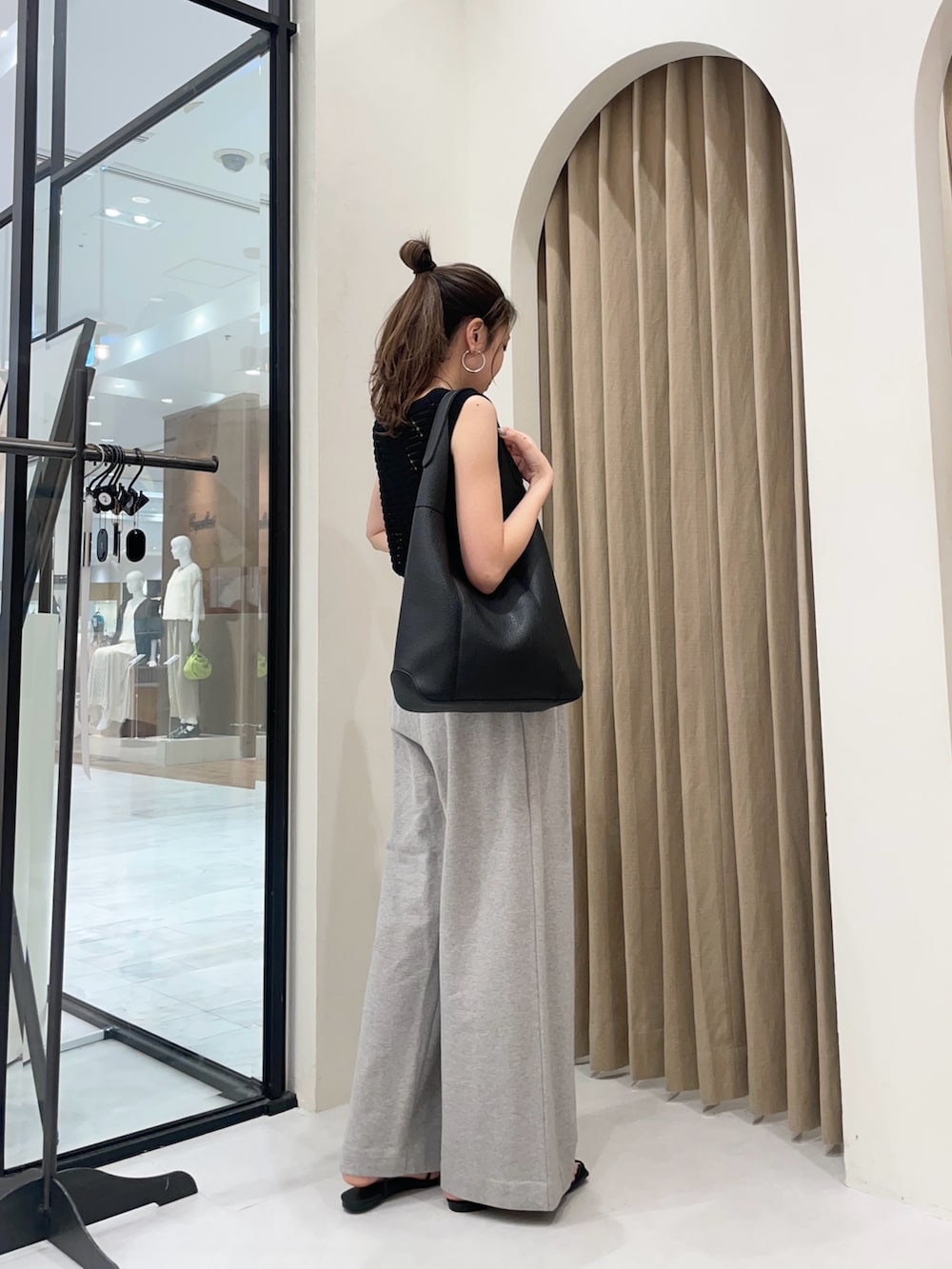 グレー系のその他パンツ、ブラック系のサンダル、ブラック系のトートバッグを着用したレディースの夏コーディネートの2枚目の写真