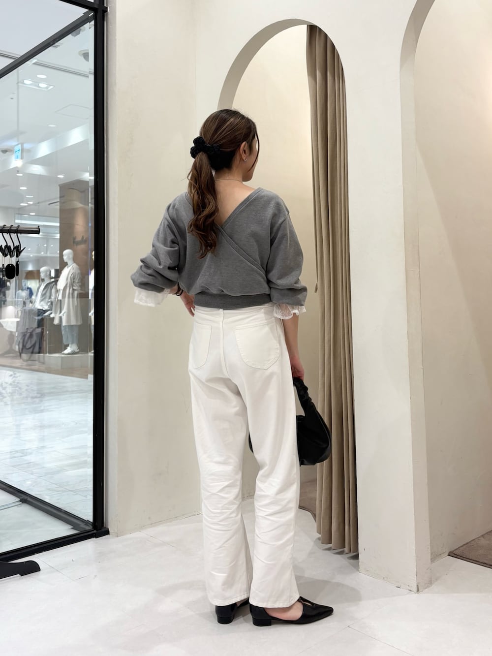 グレー系のTシャツ/カットソー、ブラック系のショルダーバッグ、ブラック系のパンプスを着用したレディースの春コーディネートの2枚目の写真