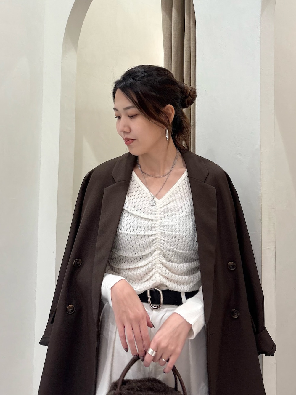 ホワイト系のニット/セーター、ブラウン系のテーラードジャケット、ブラウン系のボストンバッグを着用したレディースの秋コーディネートの5枚目の写真