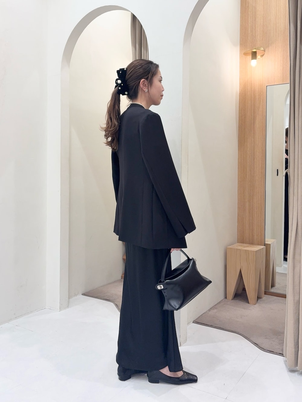 ブラック系のテーラードジャケット、ブラック系のシャツ/ブラウス、ブラック系のスカートを着用したレディースの冬コーディネートの2枚目の写真