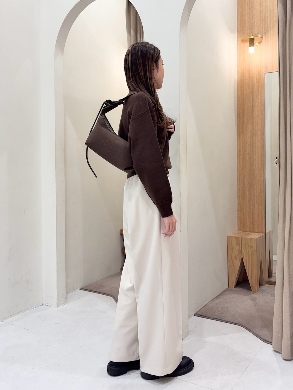 ブラウン系のニット/セーター、ブラウン系のトートバッグ、ホワイト系のその他パンツを着用したレディースの秋コーディネートの2枚目の写真