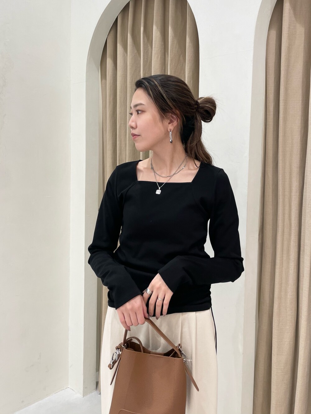 ブラック系のTシャツ/カットソー、ホワイト系のその他パンツ、ブラウン系のショルダーバッグを着用したレディースの春コーディネートの3枚目の写真