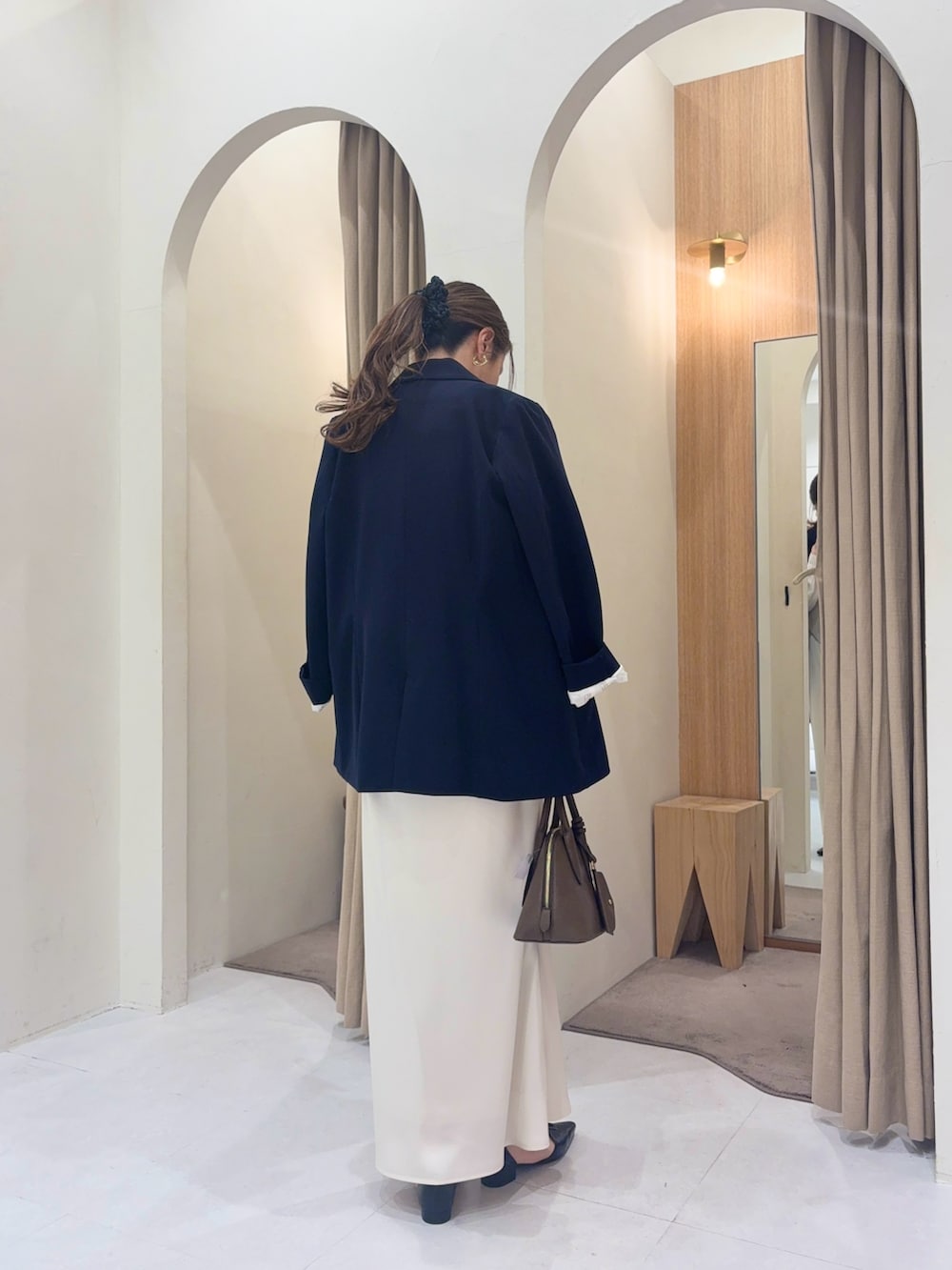 ブルー系のテーラードジャケット、ホワイト系のシャツ/ブラウス、ホワイト系のスカートを着用したレディースの冬コーディネートの3枚目の写真