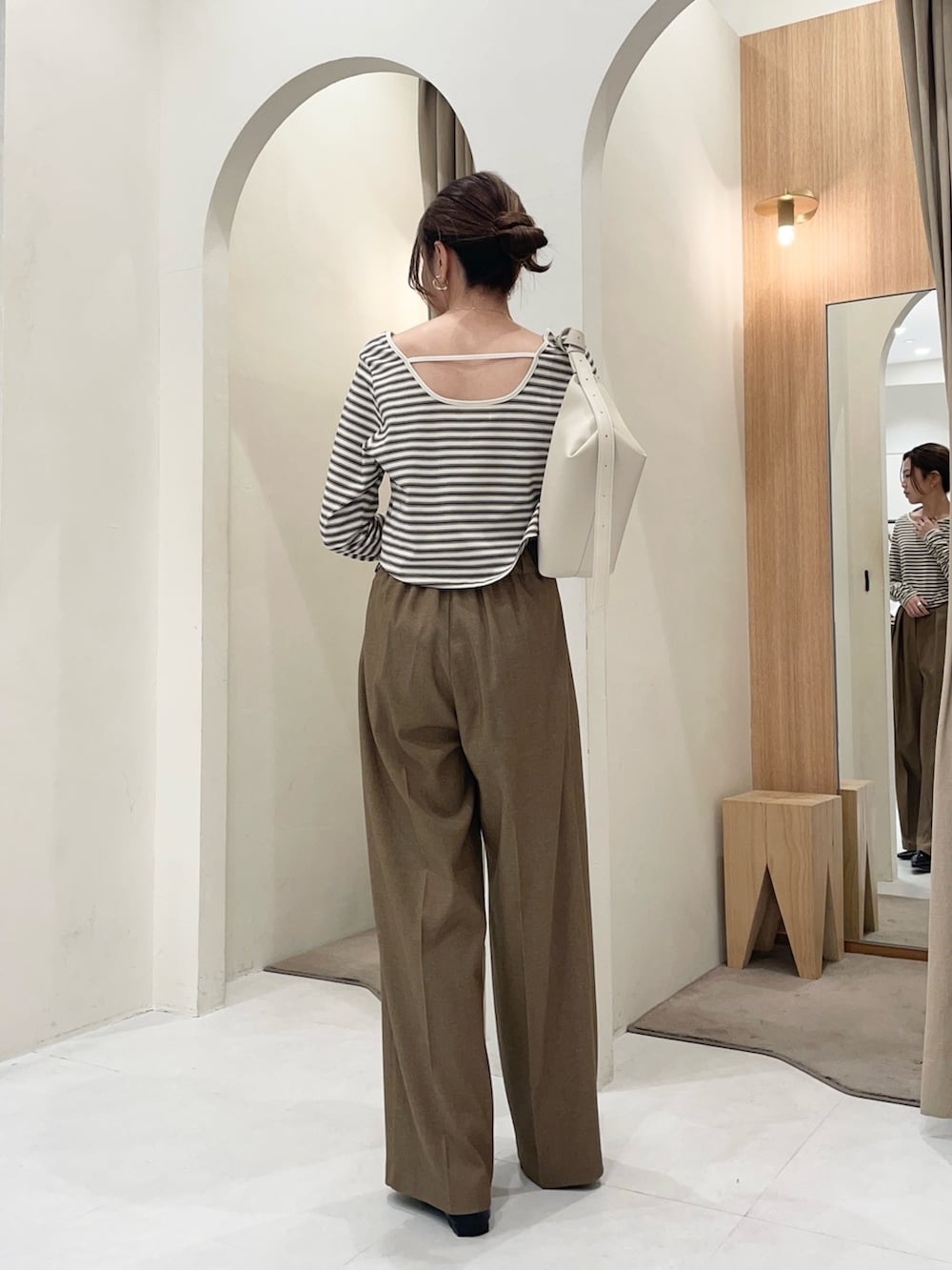 ホワイト系のTシャツ/カットソー、ホワイト系のショルダーバッグ、ブラウン系のその他パンツを着用したレディースの冬コーディネートの2枚目の写真