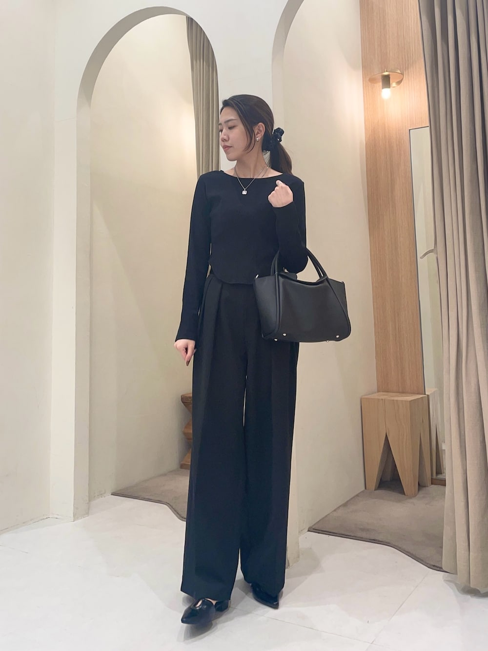 ブラック系のTシャツ/カットソー、ブラック系のパンプス、ブラック系のショルダーバッグを着用したレディースの春コーディネートの2枚目の写真