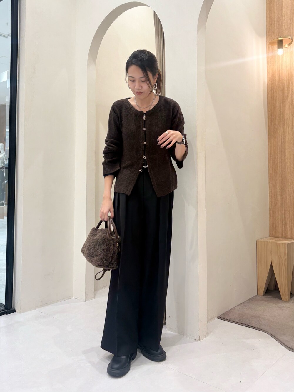 ブラウン系のカーディガン/ボレロ、ブラウン系のボストンバッグ、ブラック系のその他パンツを着用したレディースの秋コーディネートの2枚目の写真